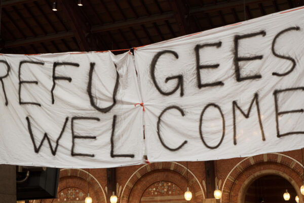 Handmade banner Refugees Welcome is hanged in Copenhagen railroad station by the place where locals bring clothes for refugees.